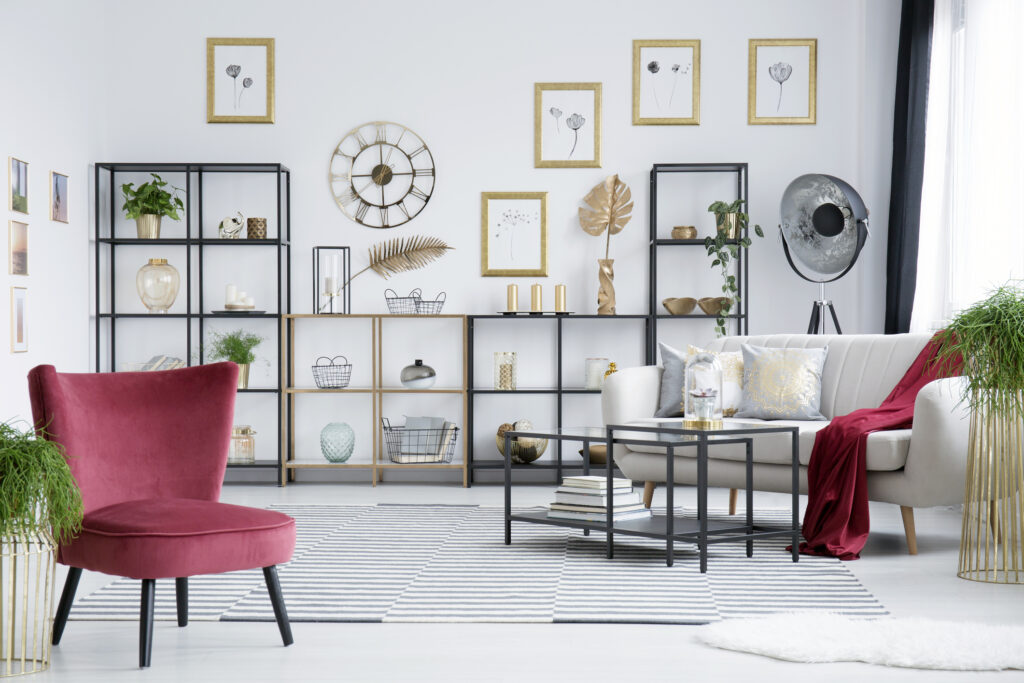 Black lamp standing next to the window in elegant living room interior with white and cherry pink furniture